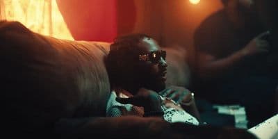 a man sitting on a couch with a remote in his hand