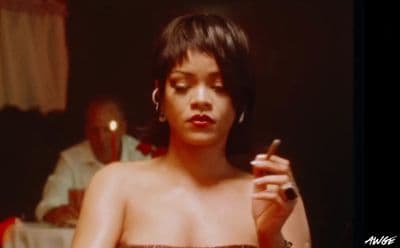 a woman in a strapless dress smoking a cigarette