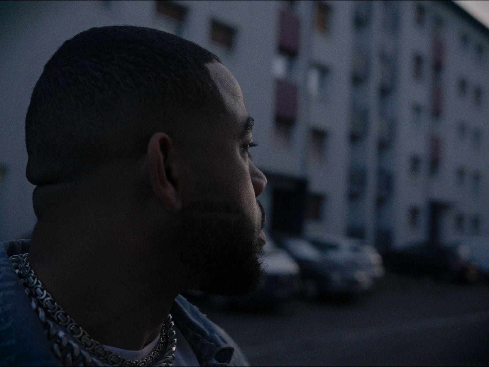 a man with a beard standing in front of a building