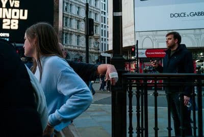 a man standing next to a woman on a street