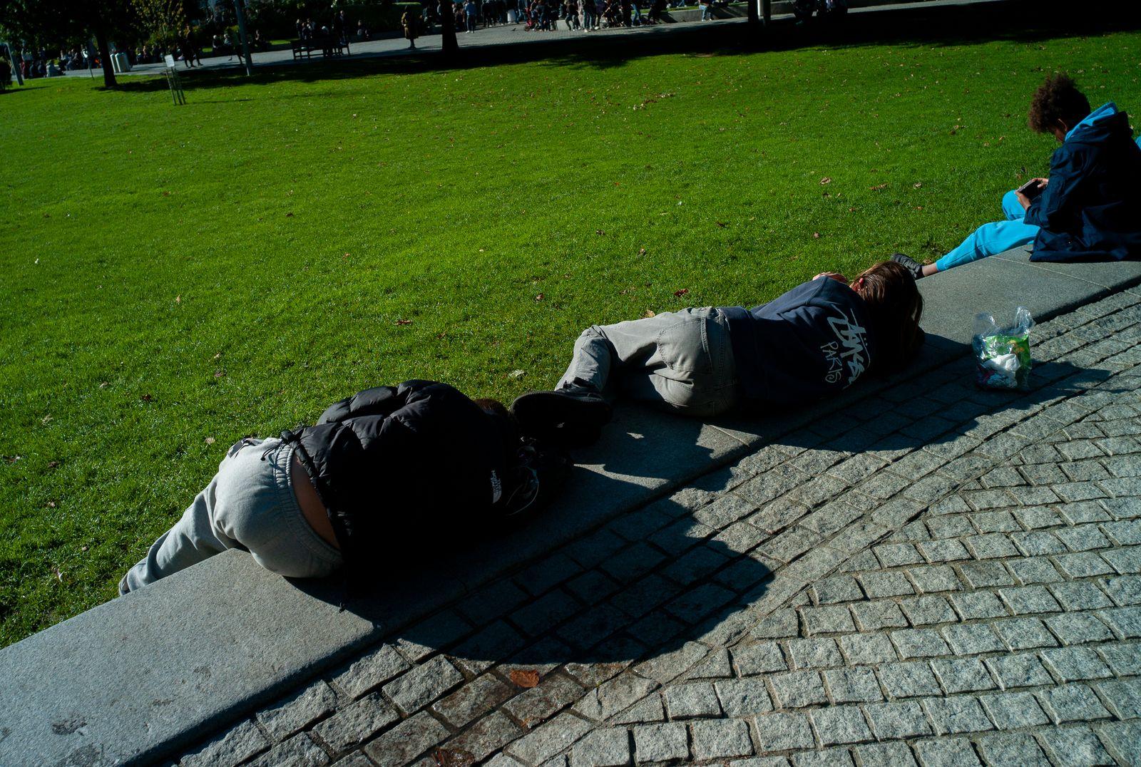 a couple of people laying on top of a sidewalk
