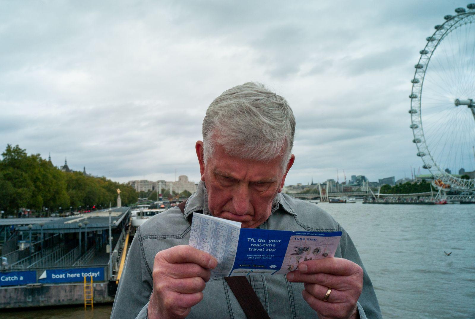 a man is looking at a ticket with a ferris wheel in the background