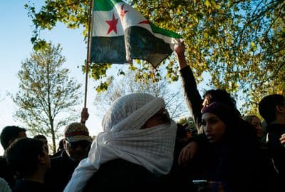 a group of people standing around each other holding a flag