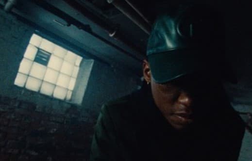 a man wearing a green hat in a dark room