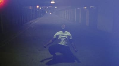 a man kneeling down in the middle of a street