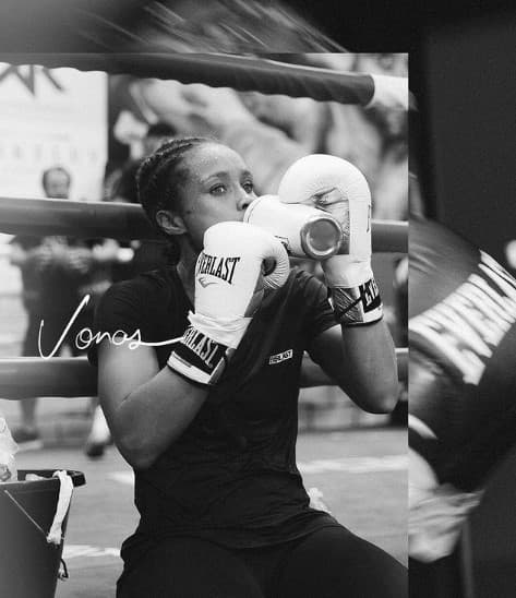 a black and white photo of a woman wearing boxing gloves