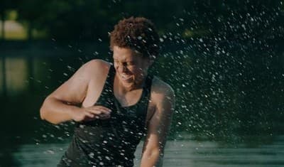 a woman in a black tank top splashing water