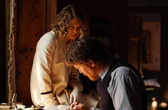 a man and a woman are looking at a piece of paper