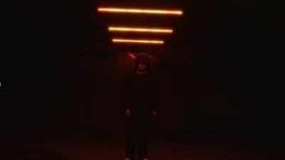 a person standing in a dark room with a red light