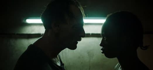 a man and a woman standing in a dark room