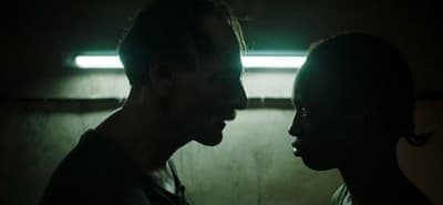 a man and a woman standing in a dark room