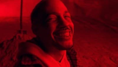 a man smiling in a red light room