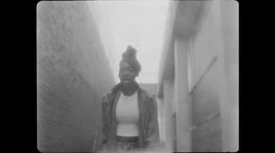 a black and white photo of a person walking down a hallway