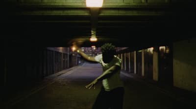 a man is skateboarding in a dark tunnel