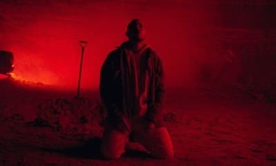 a man standing in front of a red light