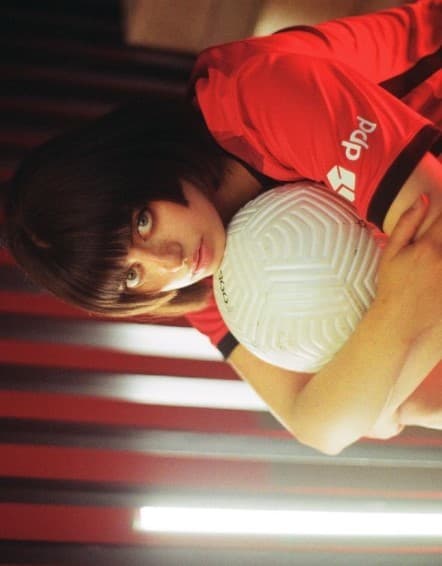 a girl in a red shirt holding a white ball