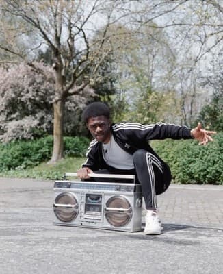 a man sitting on top of a boom box