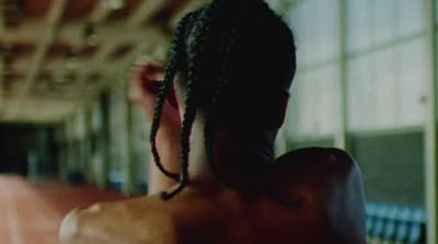 a man with dreadlocks standing in a building