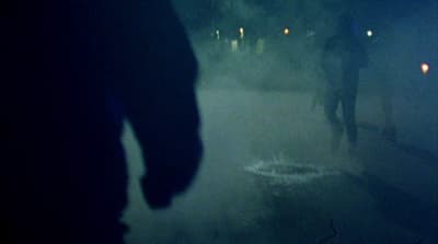 a group of people walking down a street at night