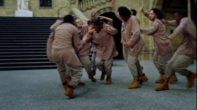 a group of people dancing in front of a building