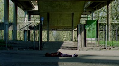 a person laying on the ground under a bridge