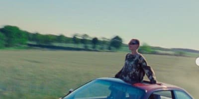 a man standing on top of a blue car