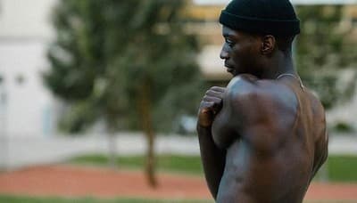 a man with no shirt on holding a frisbee