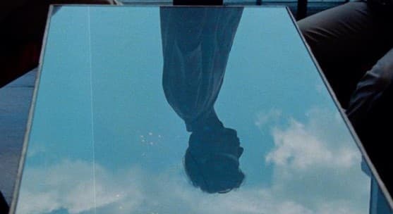 a reflection of a person's feet in a glass table