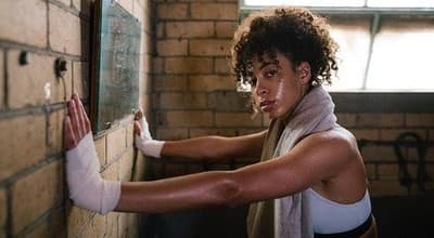 a woman in a white tank top and white gloves