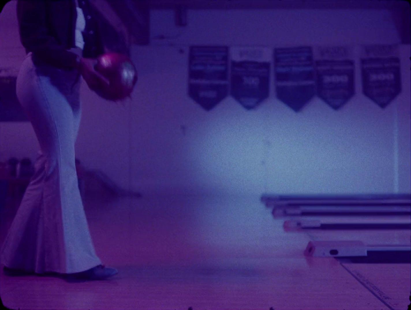 a woman in a long dress holding a bowling ball