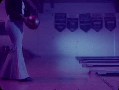 a woman in a long dress holding a bowling ball