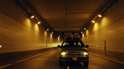 a man standing on top of a truck in a tunnel