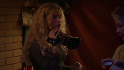 a woman holding a camera in her right hand