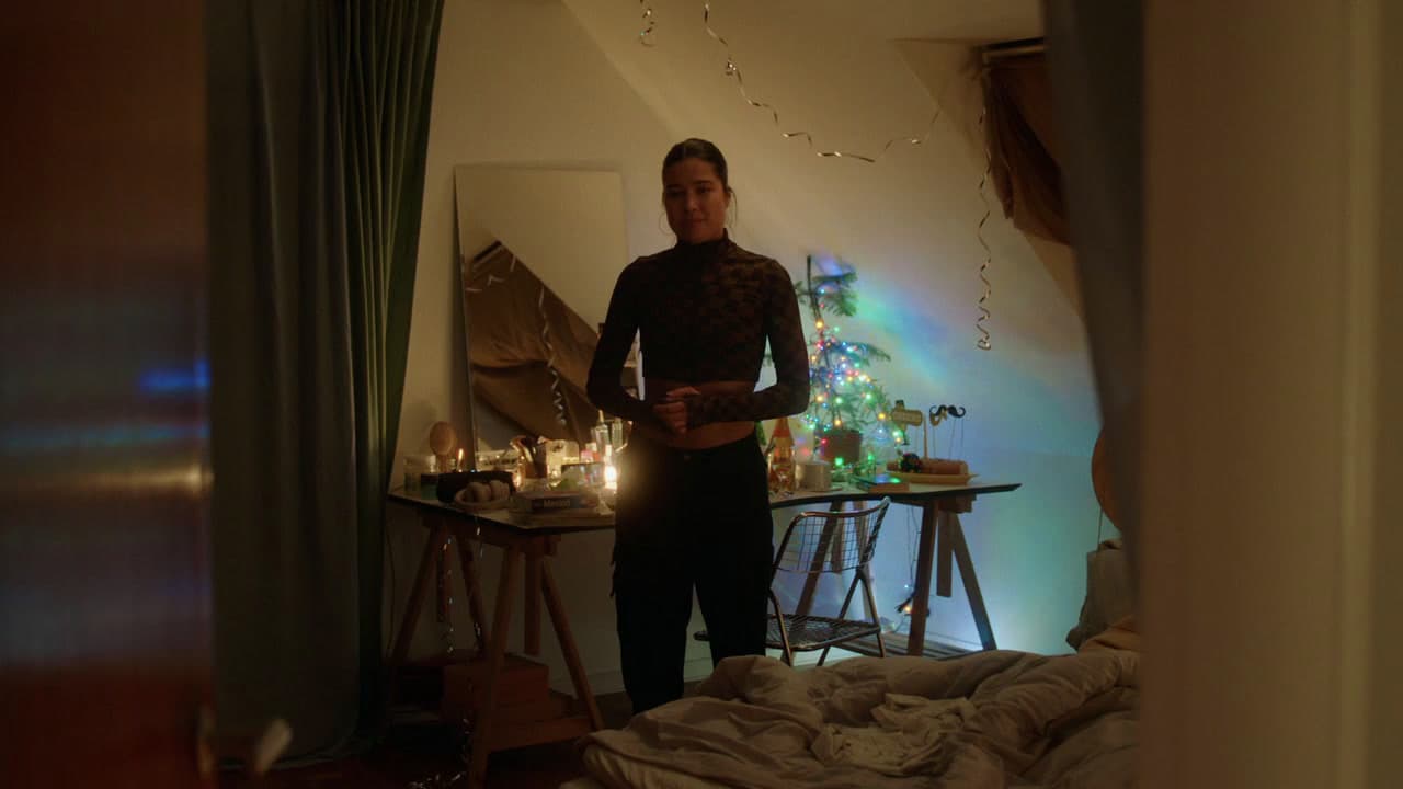 a man standing in a bedroom next to a christmas tree
