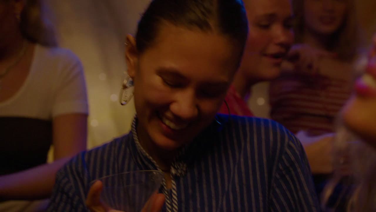 a woman is smiling and holding a wine glass