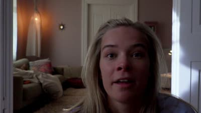 a woman standing in a living room looking at the camera