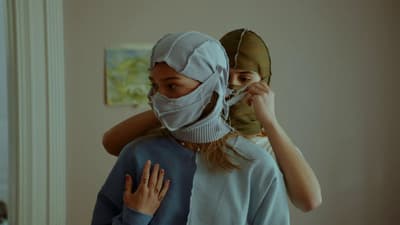 a woman with a bandage on her head and another woman covering her face with a