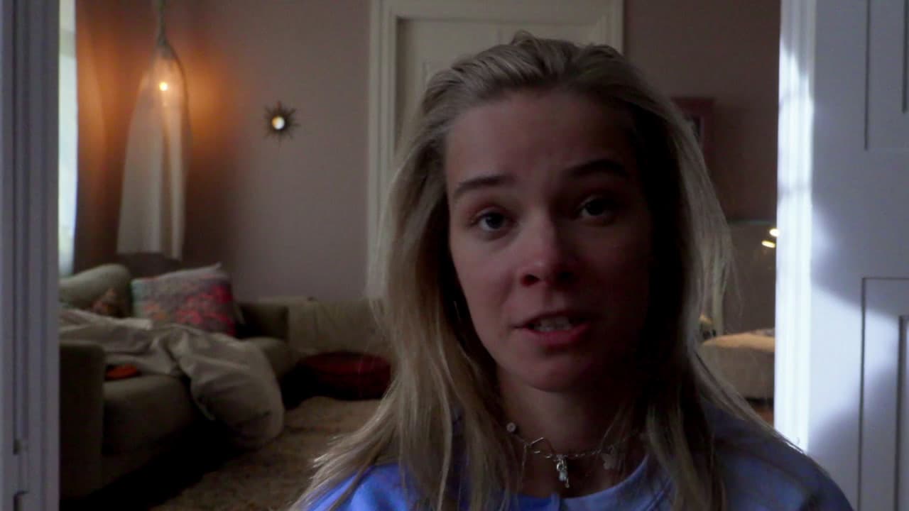 a woman in a blue shirt standing in a living room