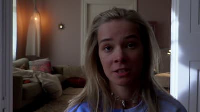 a woman in a blue shirt standing in a living room