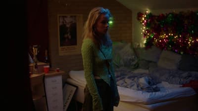 a woman standing in front of a bed in a room