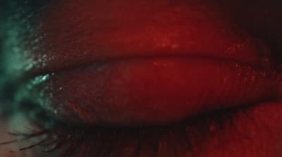 a close up of a person's eye with red lipstick
