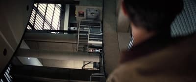 a man standing in front of a window next to a stair case