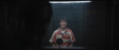 a man standing in front of a window in the dark