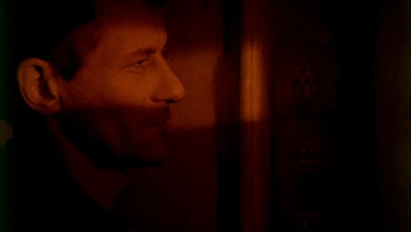 a man standing in front of a wall in a dark room