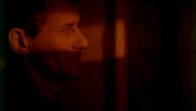 a man standing in front of a wall in a dark room