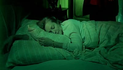 a woman laying in bed with her eyes closed