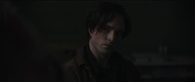 a man in a dark room looking at his cell phone