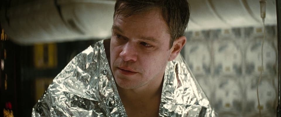 a man in a shiny jacket looking at his cell phone