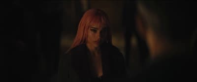 a woman with red hair standing in a dark room