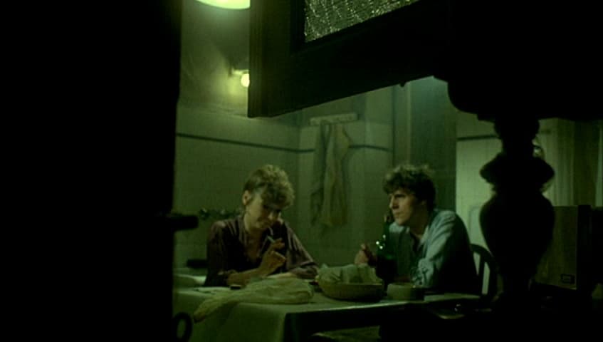 two people sitting at a table in a dark room